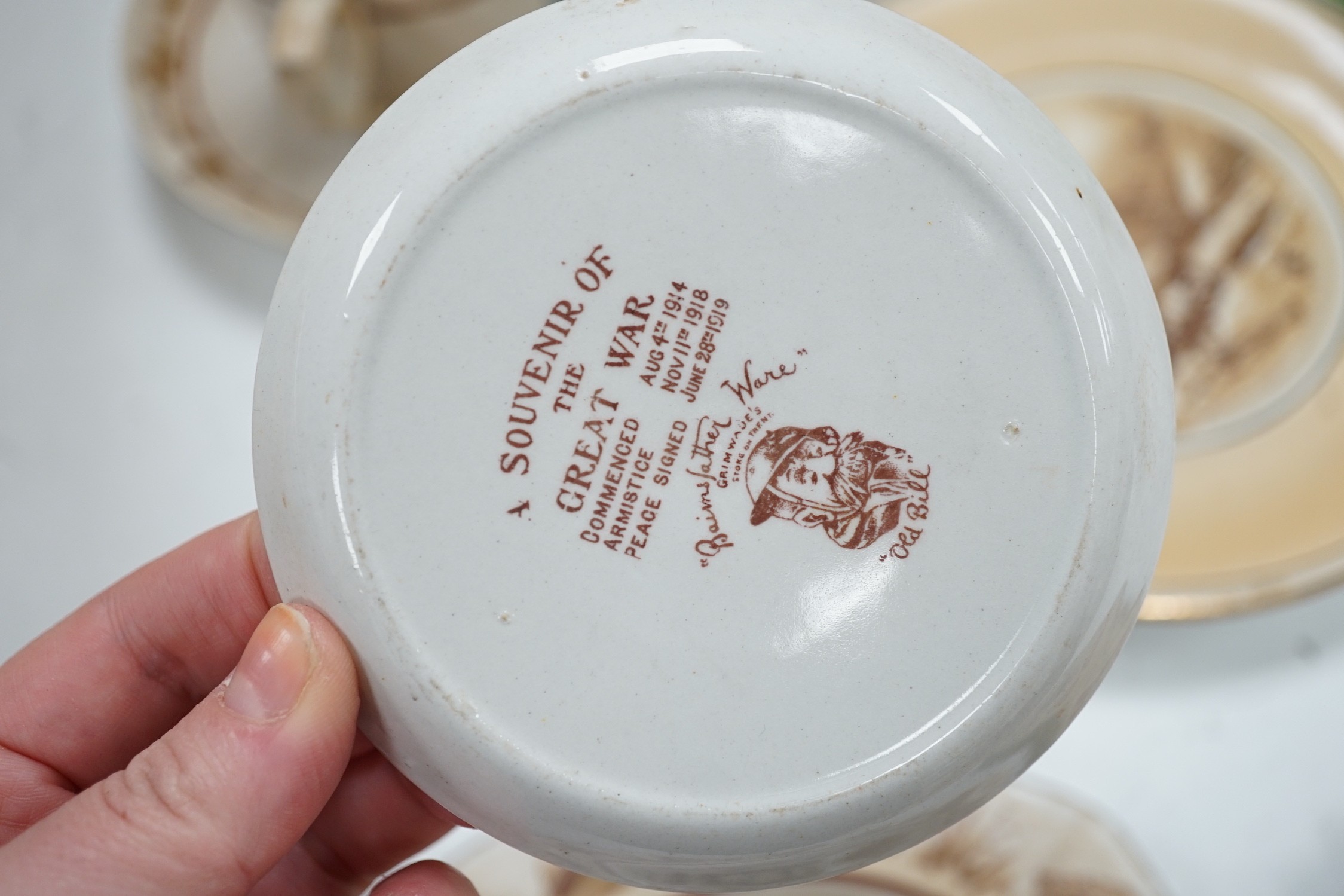 WWI commemorative Grimwades ‘Old Bill’ ceramics, including a jug, a bowl, five various dishes and a moustache cup and saucer, together with two novelty character jugs and a spy card game